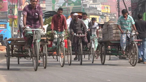 Cycle rickshaws ride through a busy street in Dhaka, Bangladesh Stock Footage