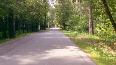 Cycle rides along narrow asphalt bicycle lane in park Video stock 110856502