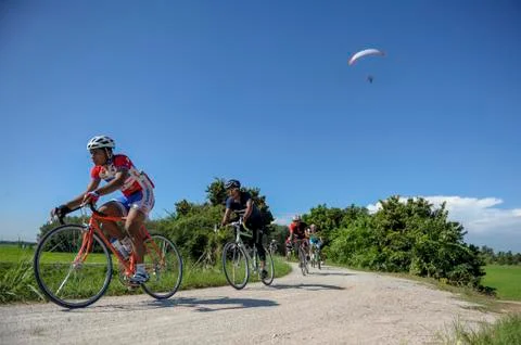 A cycling activity with the paragliding activity in the same area Stock Photos