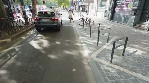 Cycling Along Tree Lined Avenue Louise in Brussels Passing a Pink Tram with Stock Footage 345279583