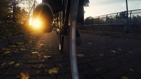 Cycling around at sunset. Low angle view of bicycle riding Stock Footage 70839272