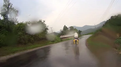 Cycling on a raining day in Laos. Stock Footage 50992279