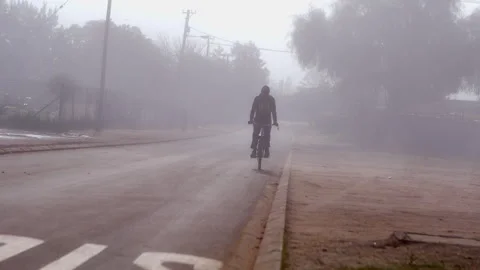 Cycling on a road through a very thick haze. Stock Footage 242010889