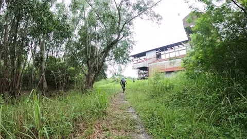 Cycling to Sri Banting Tin Mining Dredge Stock Footage 144612670