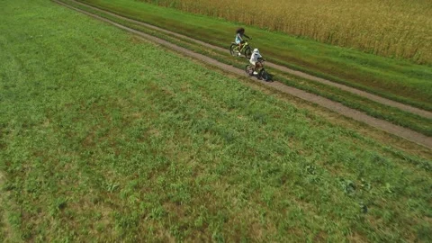 Cycling through green fields on a sunny day in early summer 스톡 동영상 284070674