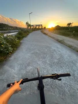 Cycling Towards Sunset on a Path Fotos de archivo