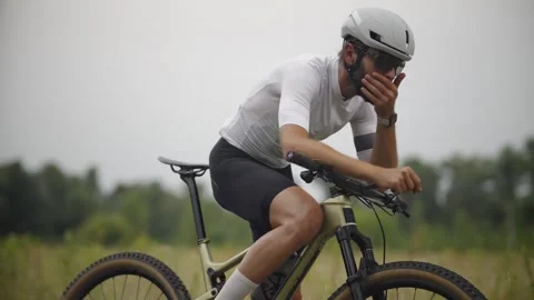 Cyclist adjusting helmet while pedaling road bike during endurance training Stock Footage 313951366