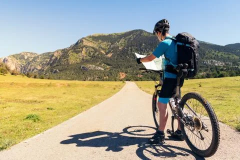 Cyclist with backpack consulting a route on a map Stock Photos