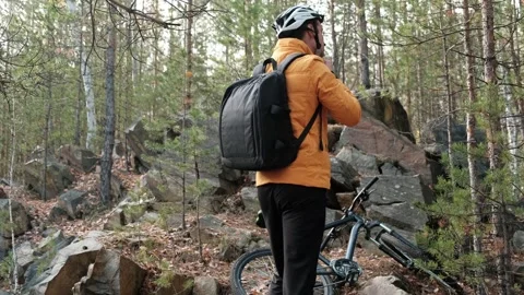 Cyclist with a backpack puts on a protective helmet Stock Footage 253983763
