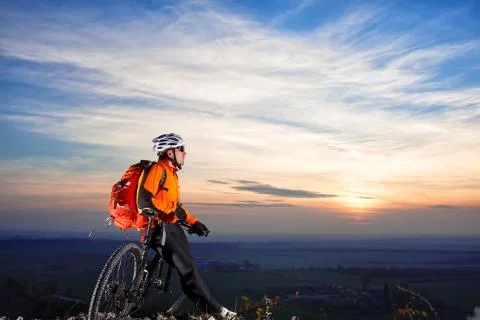 Cyclist with backpack on the top of a hill Stock Photos