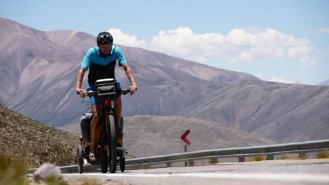 Cyclist On A Bicycle With A Trailer Overcomes A High Pass In The Andes Mountains Stock Footage 168057459
