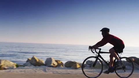 Cyclist Bikes by the Ocean 스톡 동영상 62890556
