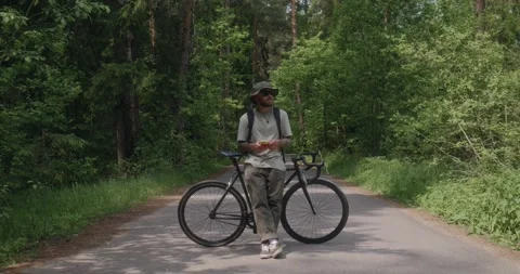 Cyclist blocks road while using phone, camera slowly moves in Stock Footage 311920591