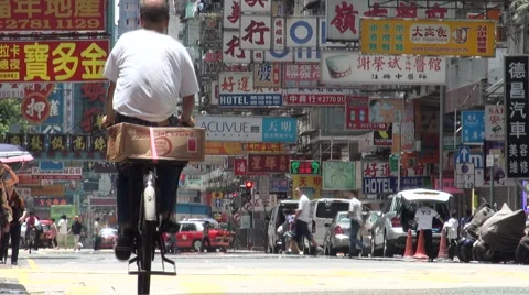 Cyclist in character filled road Kowloon, street in Hong Kong Stock Footage