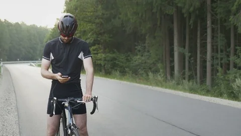 Cyclist checking his mobile phone on the ride Stock Footage 75509735
