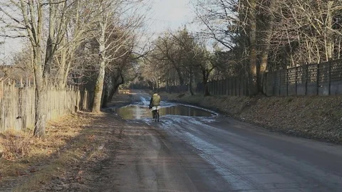 Cyclist circles large puddle Stock Footage 70906019