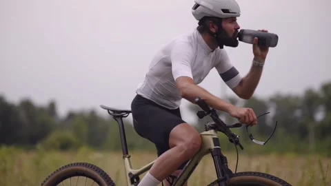 Cyclist drinking water while riding road bike during training ride for hydration Stock Footage 313951375