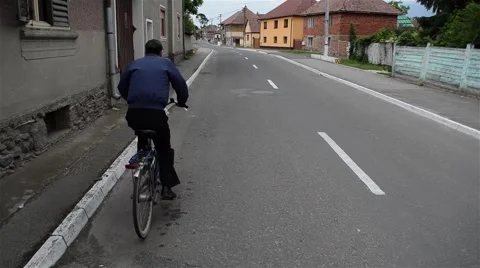 Cyclist goes on the left side of the asphalt road hurrying home Stock Footage 59588381