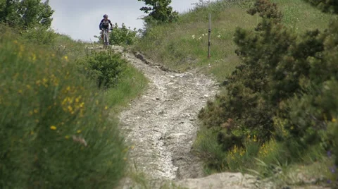 Cyclist going downhill on dirt patch Stock Footage 36696625
