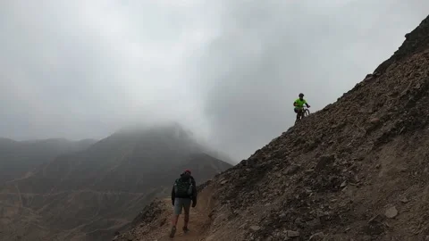 Cyclist going up a narrow path up a steep hill. Video stock 145102435