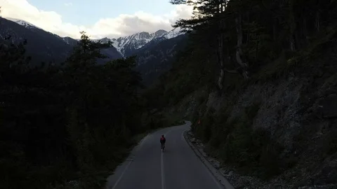 Cyclist going uphill on a beautiful paved mountain road in Greece Stock Footage 107777211