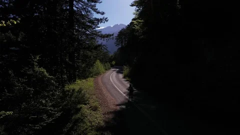 Cyclist going uphill on a beautiful paved mountain road in Greece Stock Footage 107777442