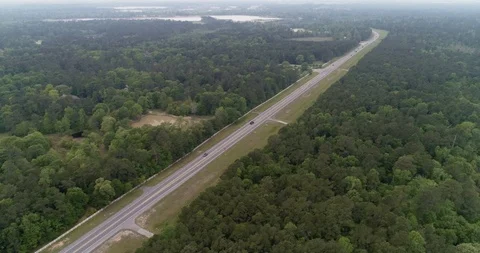 Cyclist in high visibility jacket on busy road through forest drone aerial 4K Stock Footage 111362230