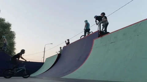 Cyclist jumps on a slide in a skate park and rotate a bicycle in the air 스톡 동영상 103242525