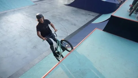 Cyclist jumps up on a springboard and perform the trick but he fails Video stock 103244848