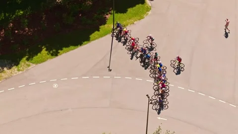 Cyclist kids line up for training start on sunny road as drone orbits overhead 스톡 동영상 313983875