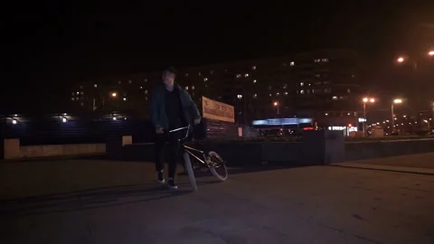 Cyclist laughs and walk down the street with the bicycle Stock-Footage 103045205