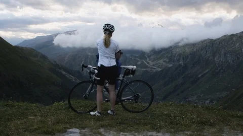 Cyclist looking out over valley Stock Footage 120018063