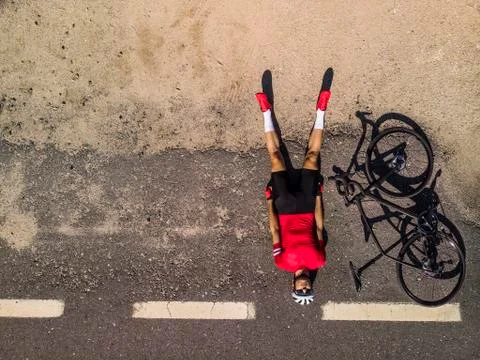 Cyclist lying on the road Stock Photos