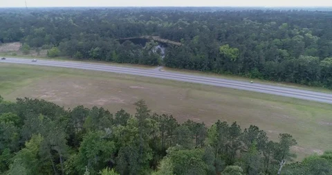 Cyclist on main road, panning up from forest drone aerial 4K Stock Footage 111362330