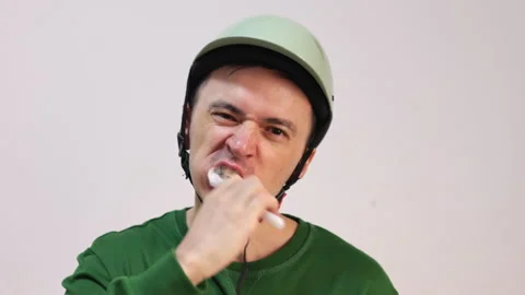 Cyclist man brushing teeth while wearing a helmet Stock Footage 344291292