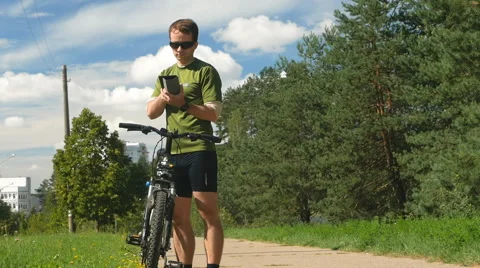 Cyclist man checks the messages on the Tablet PC. The young man in the cycling Stock Footage 66438872