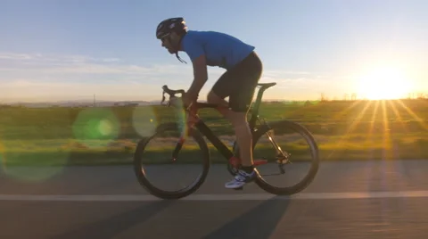 Cyclist man cycling backlit tracking shot 4k Stock Footage