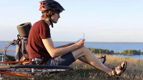 Cyclist with a map on top of the mountain Vídeo Stock 77994388