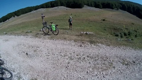  Cyclist on a mountain path lands a drone on his hand Stock Footage 113284649