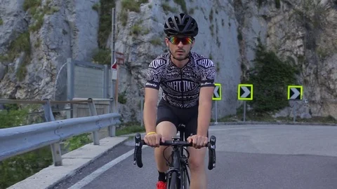 A cyclist passes a mountain bridge Stock Footage 78155056