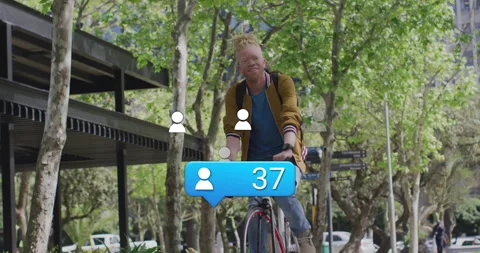 Cyclist pedaling park path while social media icon sparking bubble growing Stock Footage 314183492