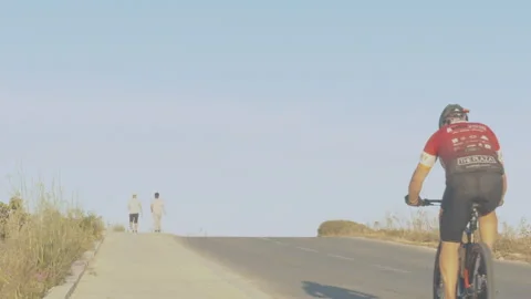 Cyclist Peddling Uphill in Slow Motion Stock Footage 131114889
