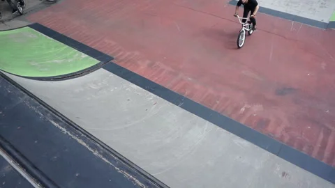 Cyclist perform trick with a flip on the slide in skate park 库存影片 103215577
