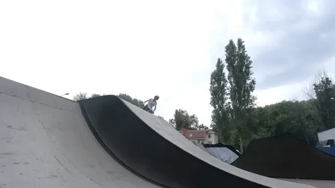 Cyclist performs a jump on the springboard in the skate park Stock Footage 103031302