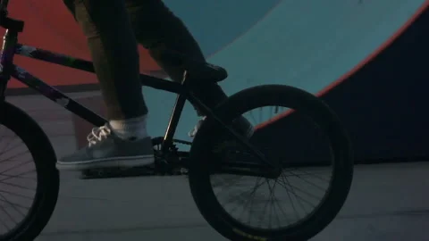 Cyclist performs a stunt in a skate park standing on one wheel Video stock 103244009