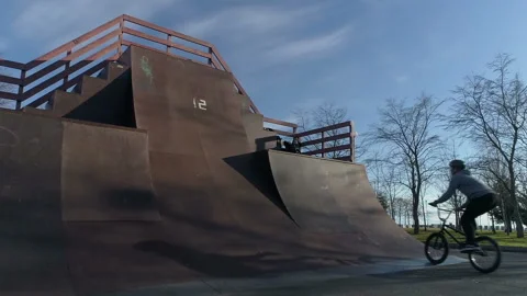 Cyclist performs the trick and is barely holding onto the bike Video stock 102513770