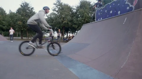 Cyclist performs a trick in and stands on one wheel his bike Video stock 103246624