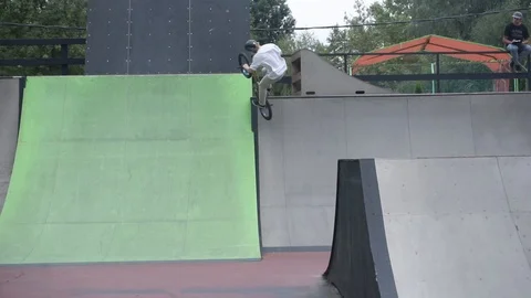 Cyclist performs tricks on springboards in skate park 스톡 동영상 103218336