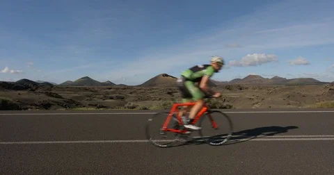 A cyclist powers along a road. Vídeo Stock 79821885