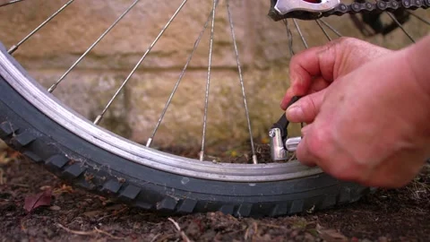 Cyclist pumping flat tyre on bicycle Stock Footage 341325781